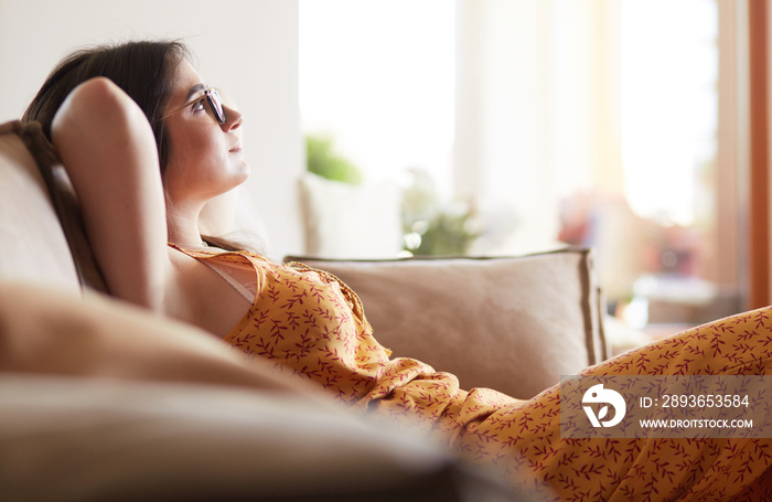 Relaxed woman sitting on a modern sofa at home