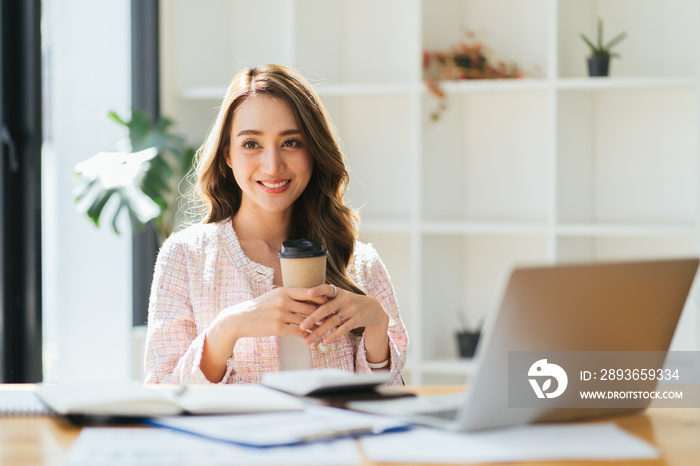 Portrait young attractive beautiful asia female sit on desk smile to camera work at home remotely co