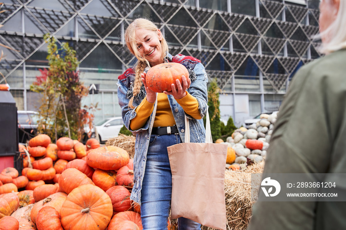 Woman choosing pumpkin at the market