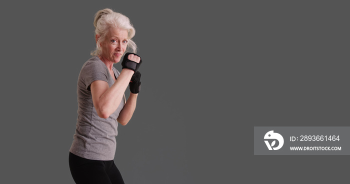 50多岁的运动女性在灰色背景下摆出武术姿势