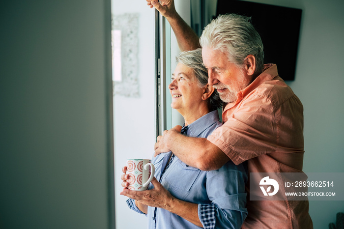 Happy old people caucasian senior couple enjoying home together drinking healthy beverage like tea a