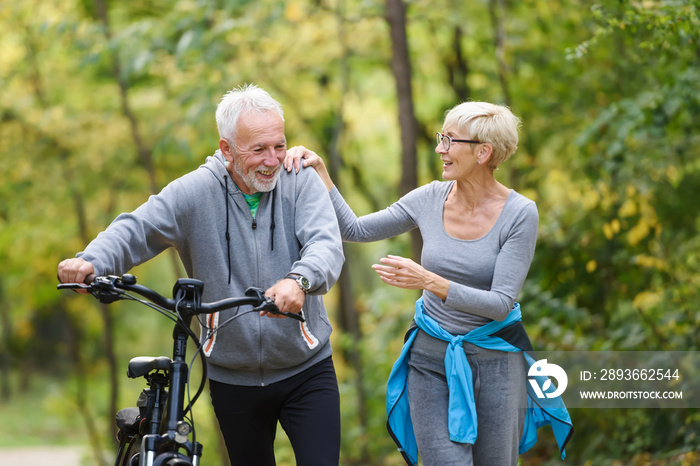 快乐活跃的老年夫妇骑着自行车一起穿过公园。这是el的完美活动