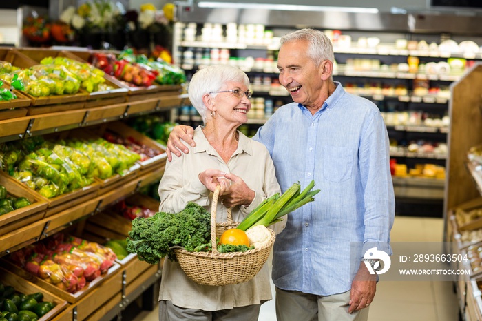 微笑的老年夫妇拿着蔬菜篮子