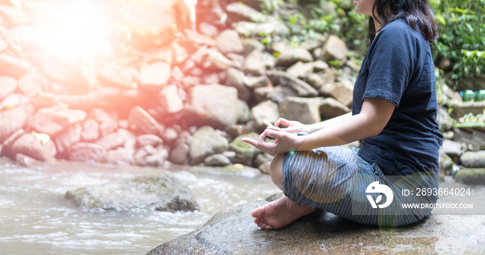 Meditate yoga hands of woman doing meditation in nature waterfall and lens flair effect.Healthcare, 