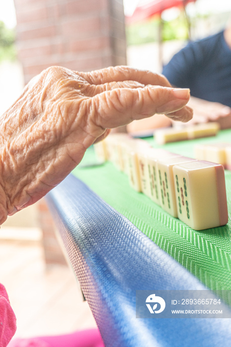 An old active elderly playing mahjong