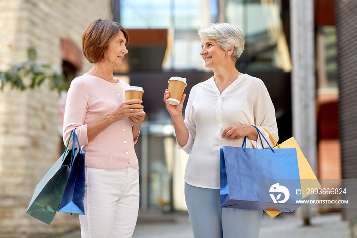 销售、消费主义和人的概念——两位资深女性或朋友拿着购物袋喝外卖