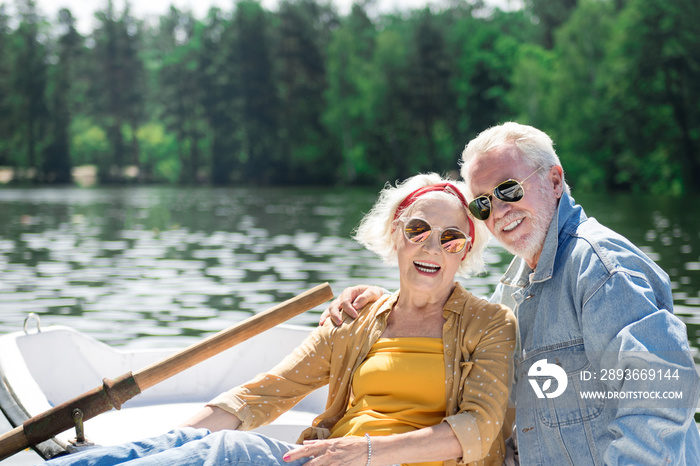 戴着太阳镜。一对积极时尚的退休夫妇戴着太阳镜开心地笑着