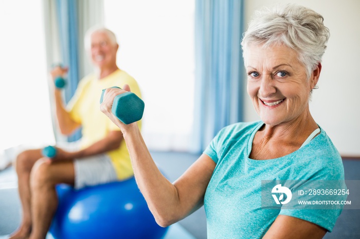 Seniors using exercise ball and weights