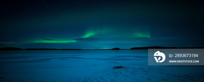 Northern lights dancing over frozen lake landscape. Farnebofjarden national park in north of Sweden.