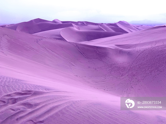 Surreal violet sand dunes in desert on alien planet.