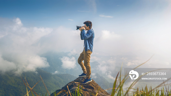 摄影师手持相机，站在大自然的岩石上。旅行理念。复古
