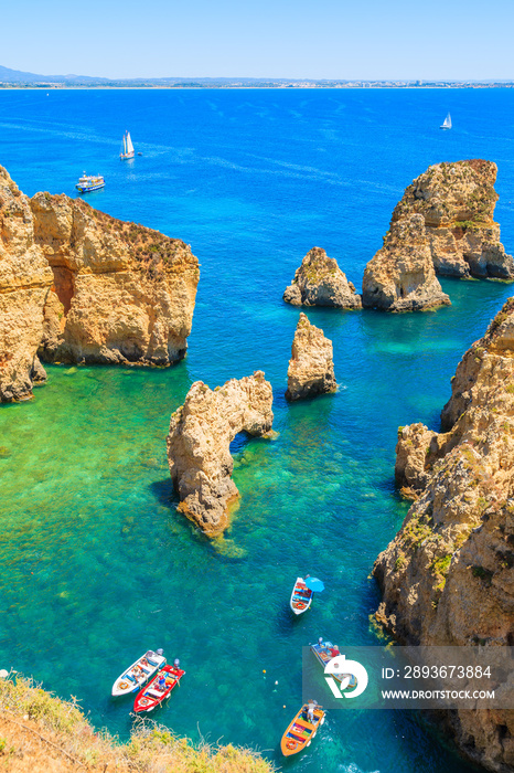 View of fishing boats on sea at Ponta da Piedade rocky coast, Algarve region, Portugal