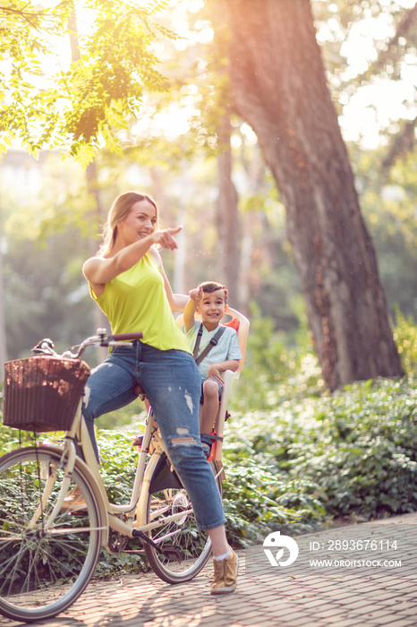 家庭运动和健康生活方式——母子俩在城市公园一起骑自行车