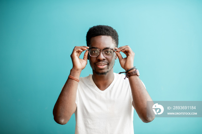 Portrait of a young african man dressed in white t-shirt standing on the colorful background