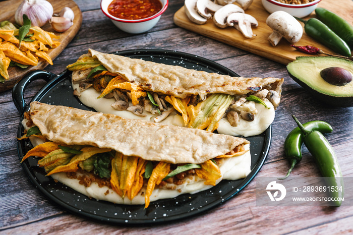 Mexican chicharrón quesadilla with oaxaca cheese and squash blossom, traditional food from the city 