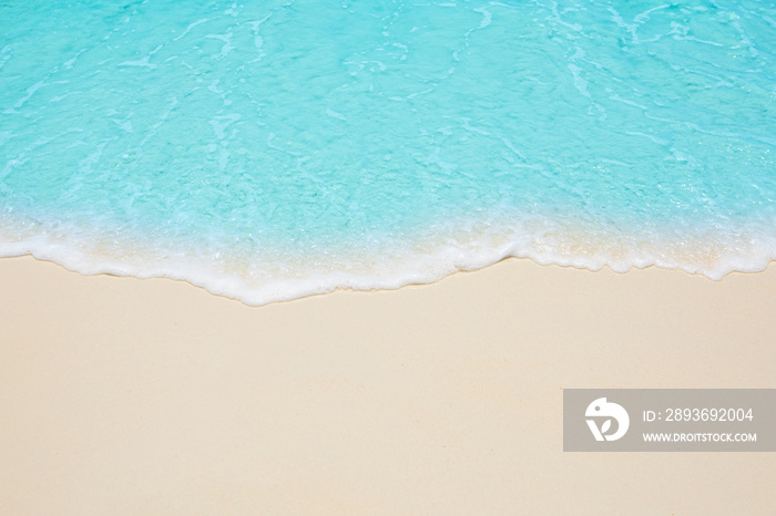 Soft waves of blue sea on the Maldives beach for the background.