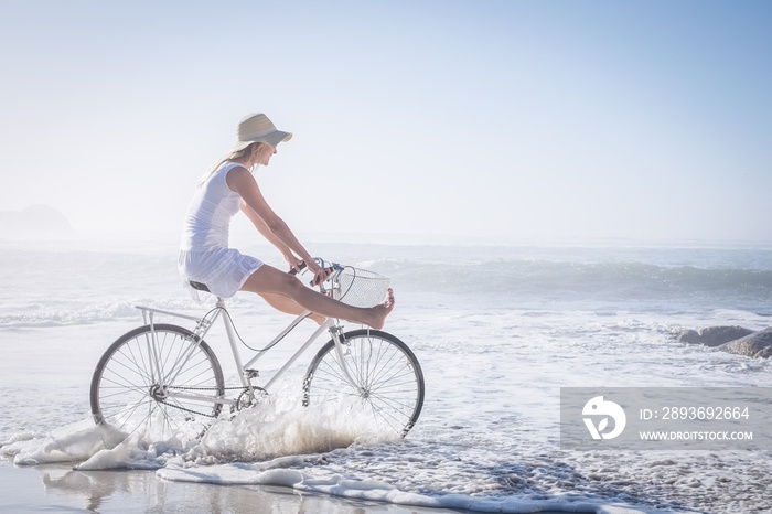 Gorgeous happy blonde on a bike ride at the beach