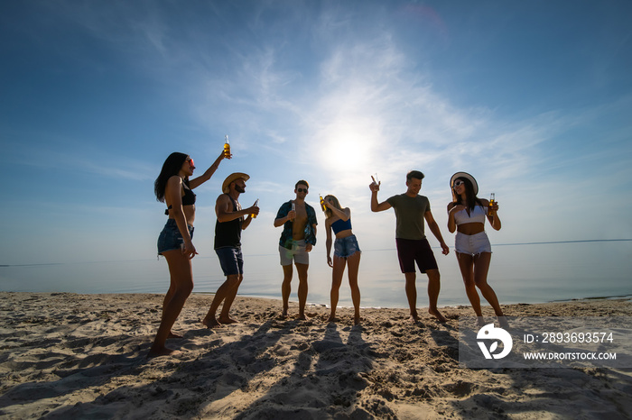 The group of friends dancing at the beach