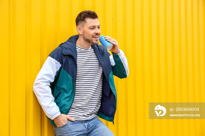 Handsome man with soda on color background