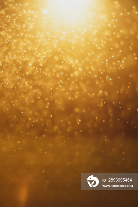 Abstract gold bokeh background image. Bokeh is caused by a blurred lens with a golden color.