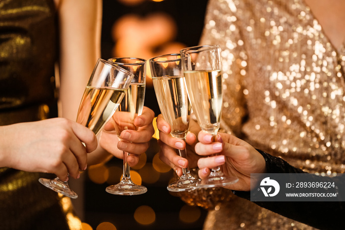 Women clinking glasses of tasty champagne at party