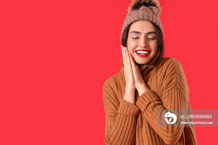 Pretty young woman in warm sweater on color background