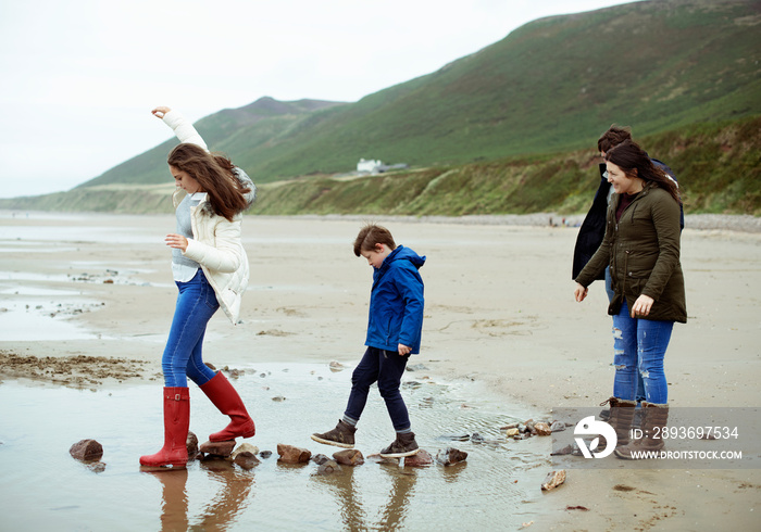 Kids walking on stones at the beach