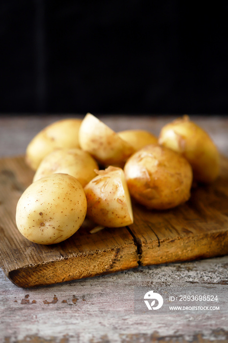 Fresh raw potatoes on a wooden surface.