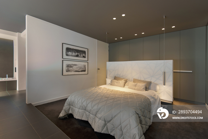 Tidy bed in spacious bedroom at contemporary house