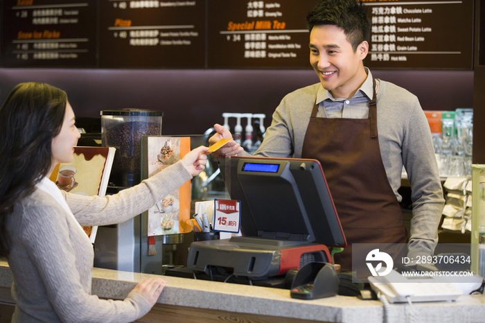 顾客在咖啡店用信用卡结账