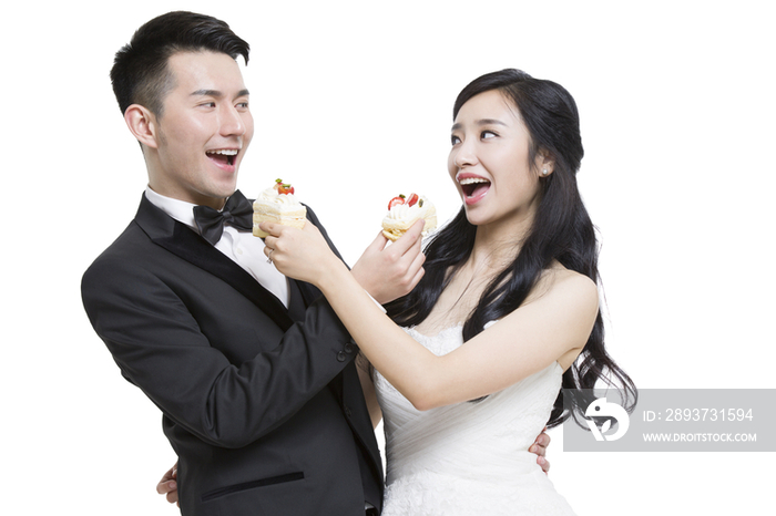 快乐的新娘和新郎吃蛋糕