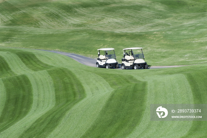 A golf course with mown fairways creating a pattern on an undulating landscape