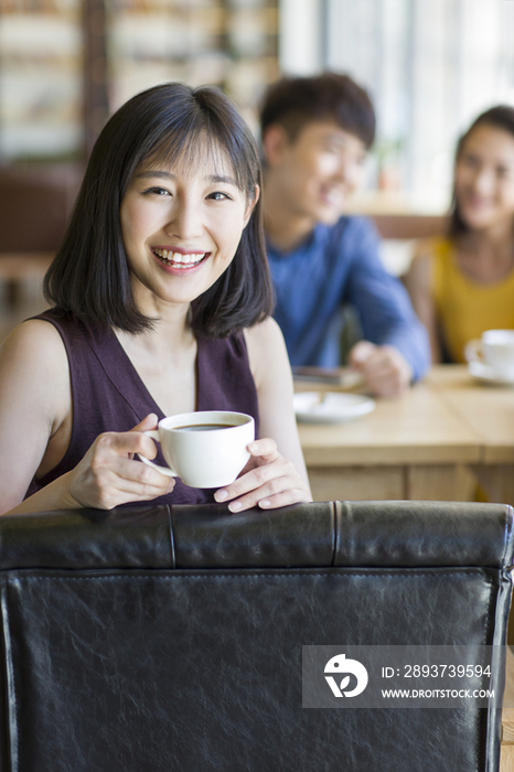 年轻女子和朋友在咖啡馆喝咖啡