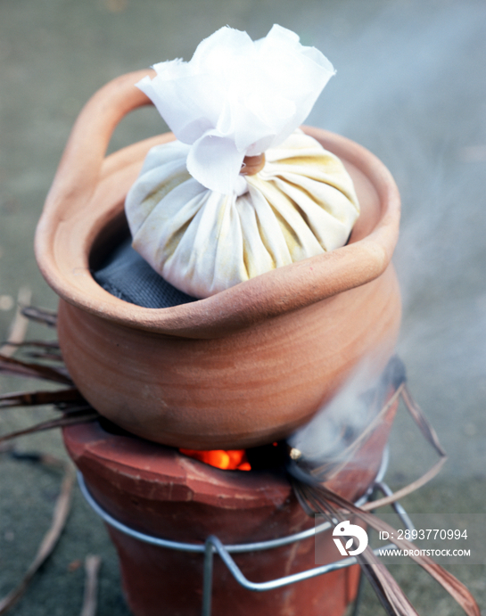 Thai herbal compress being heated Popular treatment in thailand, the compresses are applied to the 