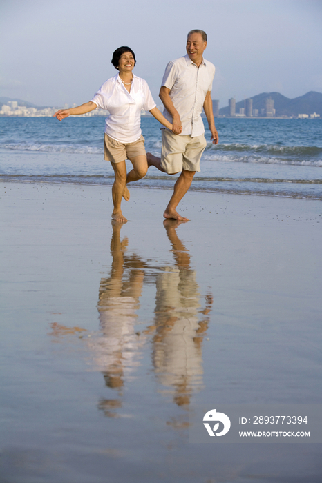 老年夫妇在海滩上奔跑