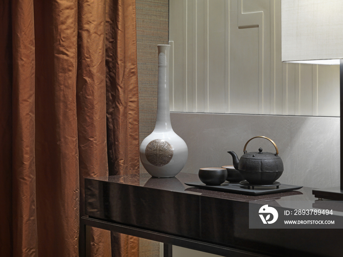 Tea tray and antique vase on table in modern hotel room