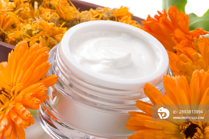 Face cream and calendula flowers