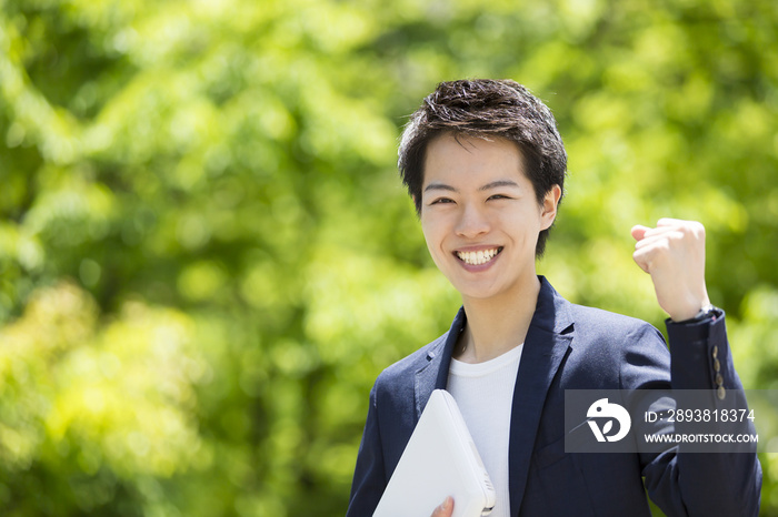 一只手拿着商务人士和学生通用的室外电脑摆出胜利的姿势