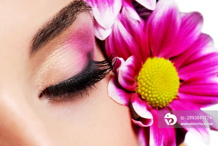 macro shot closed female eye on a flowers background