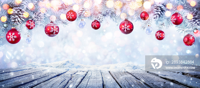 Christmas Table With Red Hanging Balls In Snowy Background