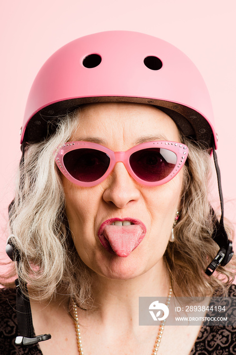 滑稽女子戴自行车头盔肖像粉红色背景真实