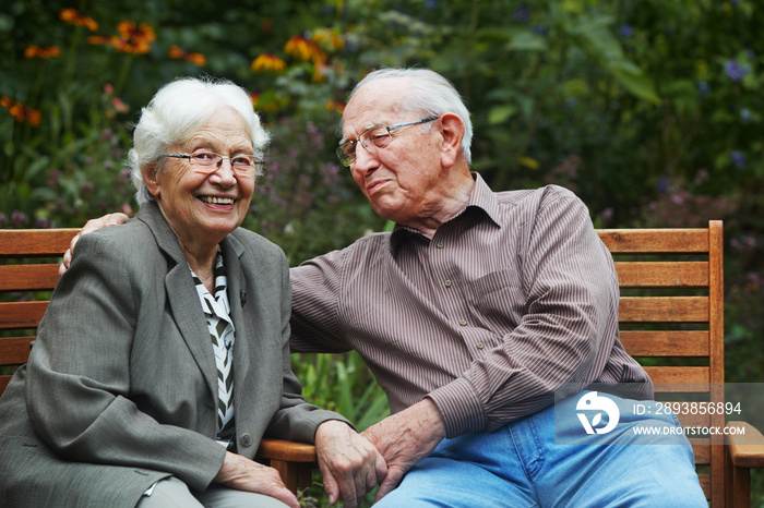 一对老夫妇坐在花园长椅上