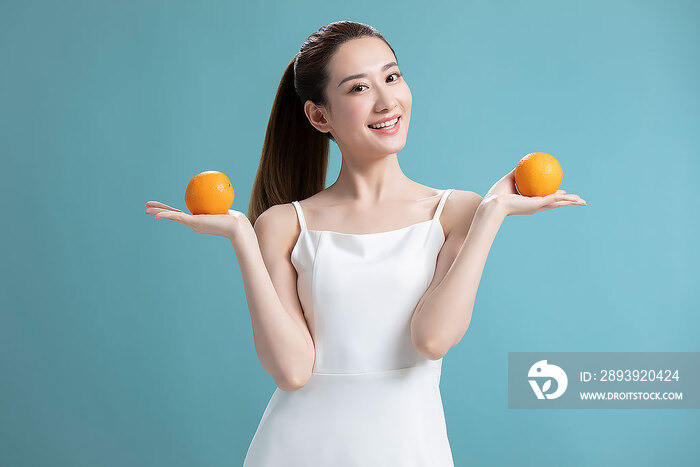年轻美女拿着橙子