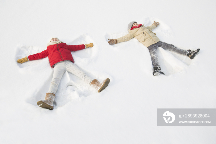 两个小孩躺在雪地上