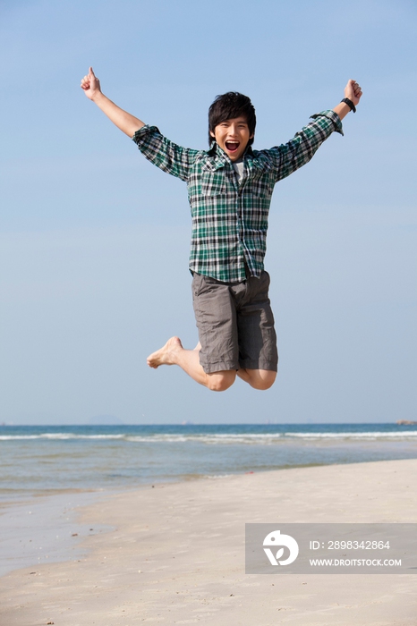 海边休闲装年轻男人跳跃