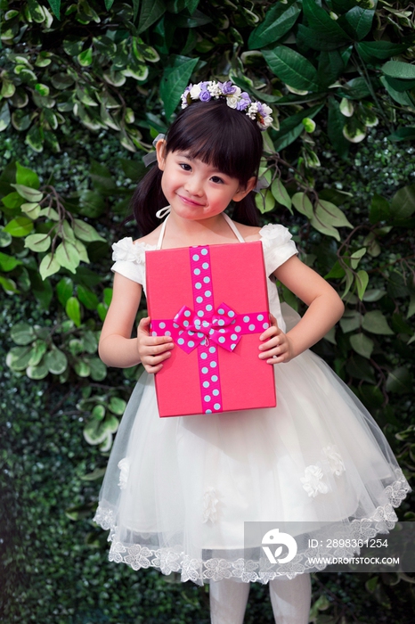 快乐的小花童抱着礼物盒
