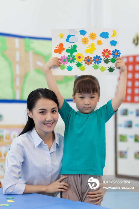 幼儿园女老师和儿童展示手工儿童画