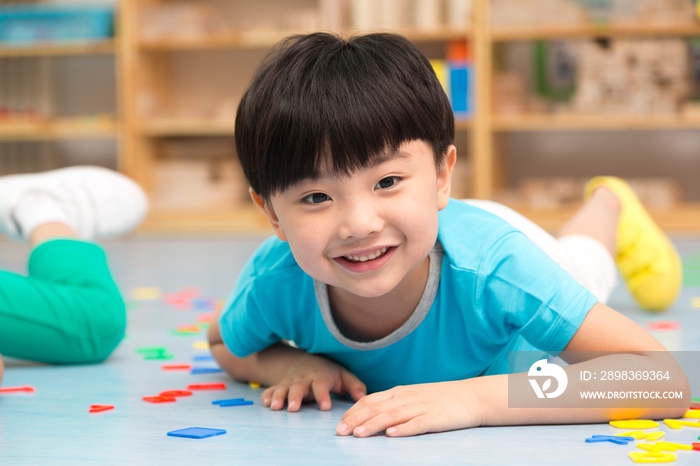 幼儿园儿童趴地板上玩玩具