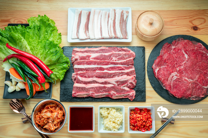 Rare Sliced Wagyu beef, Cross Cut Short Ribs beef, Slide pork belly on black plate, Red beef on wooden background, Asian asian BBQ Shabu Shabu Sukiyaki food style.