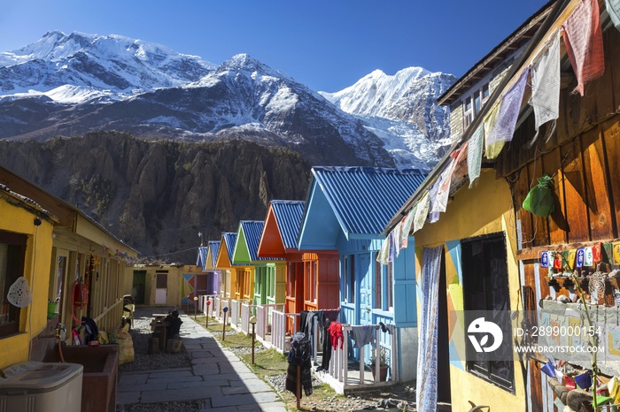 Row of Nepal Village Cottages with Snowy Himalaya Mountain Peaks in the Background on Annapurna Circuit Hiking Trek